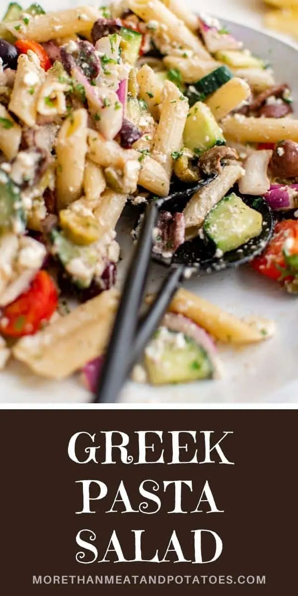 Serving spoon in a bowl of greek pasta salad.
