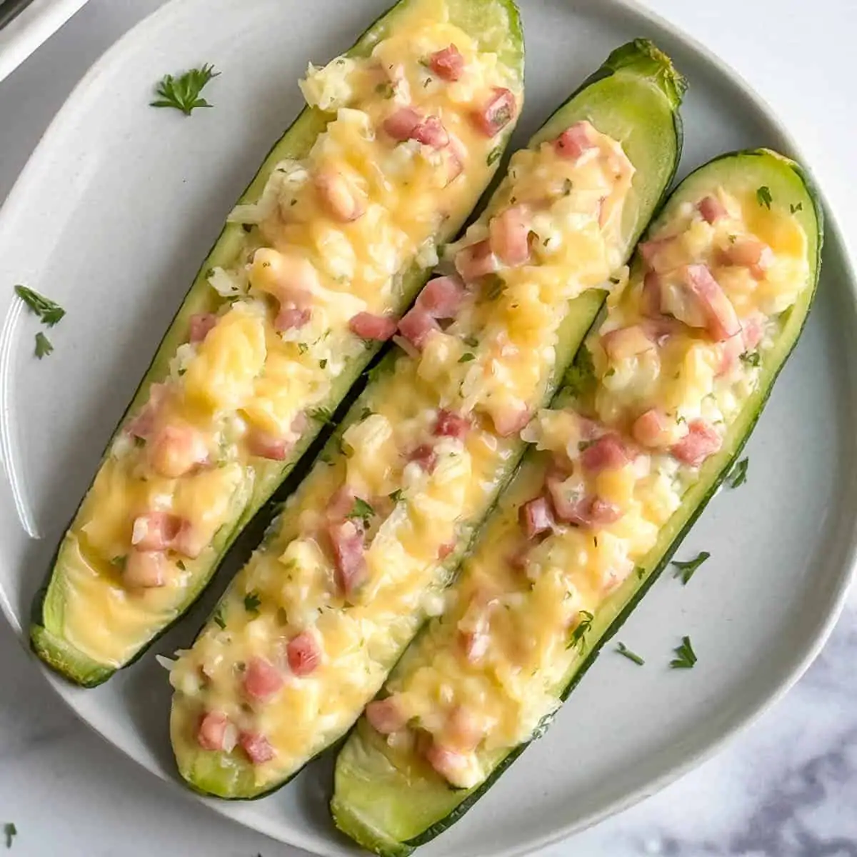 Overhead view of ham and cheese stuffed zucchini boats.