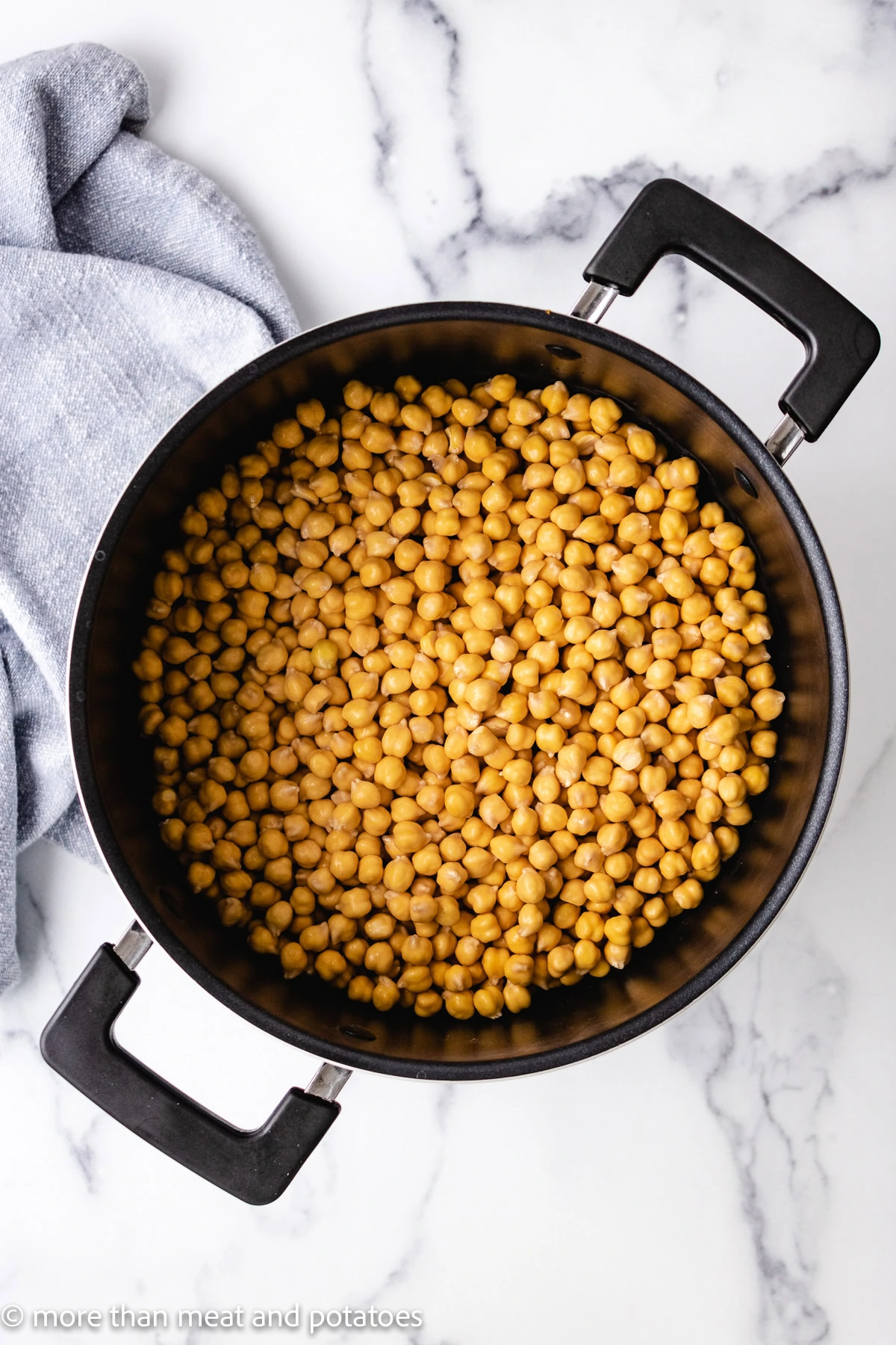 Soaked chickpeas in a large cooking pot.