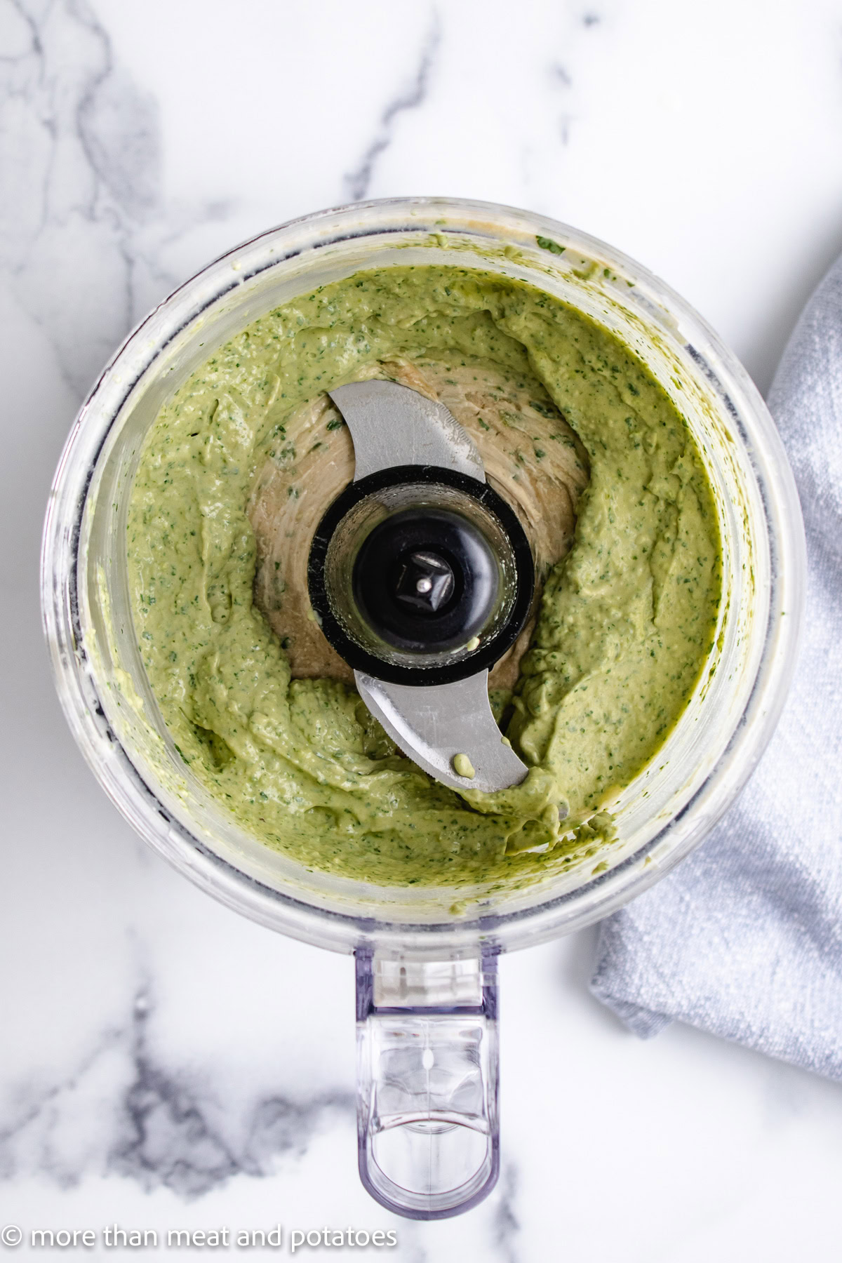Overhead view of jalape&ntilde;o cilantro hummus in a food processor.