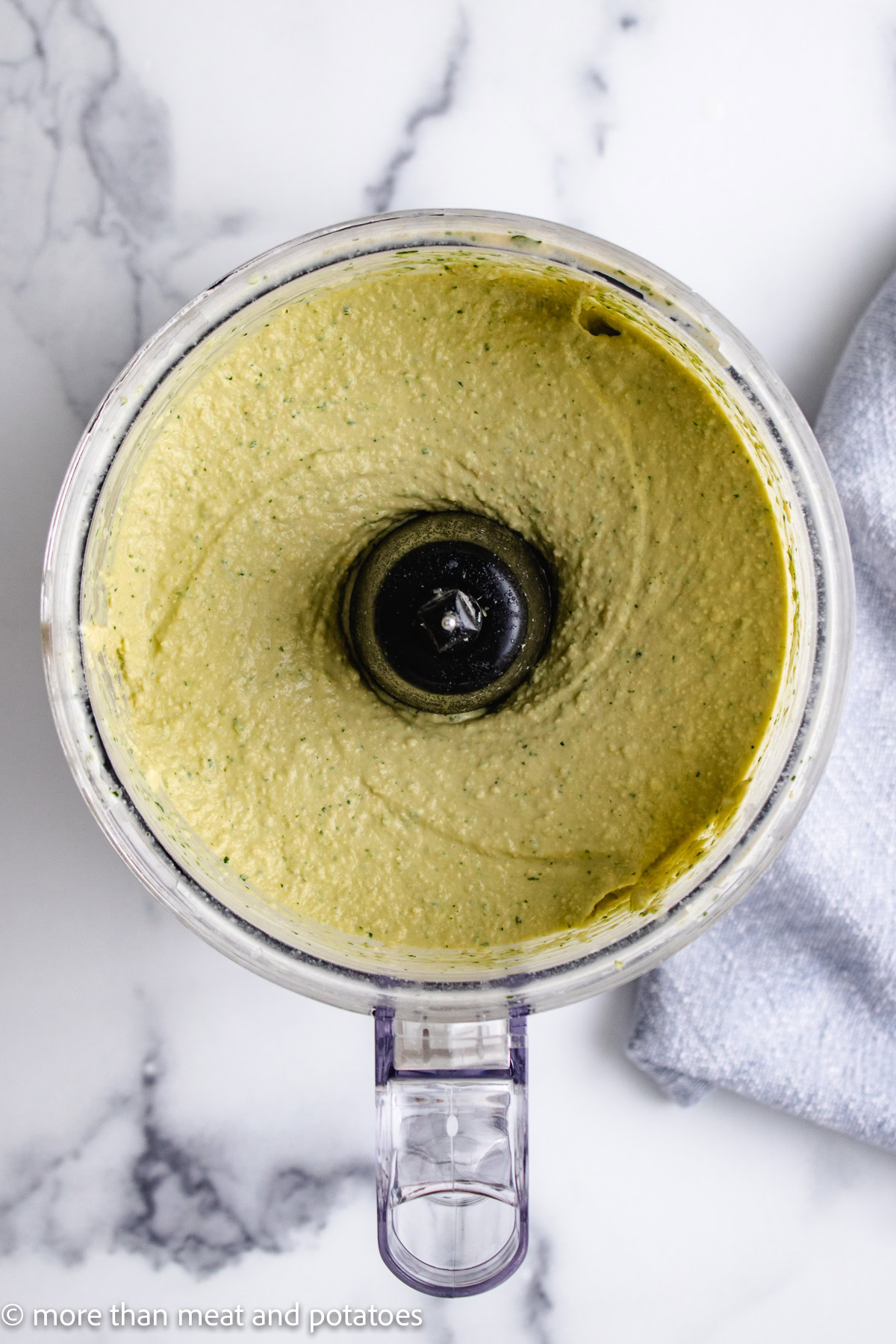 Jalape&ntilde;o hummus being made in a food processor.