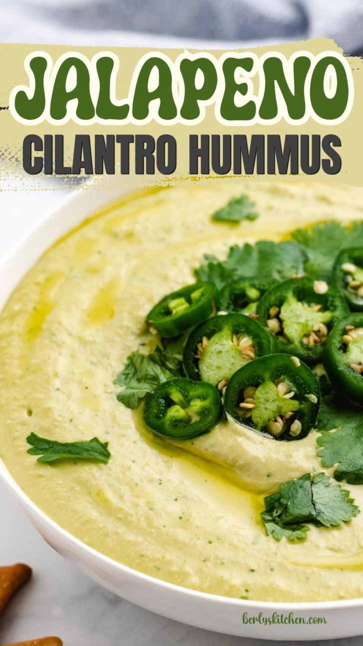 Side view of jalapeño cilantro hummus topped with fresh jalapeños.