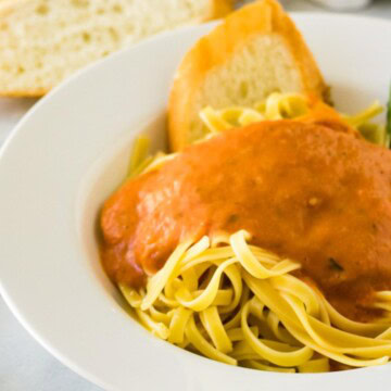 Close up view of marinara sauce over noodles.