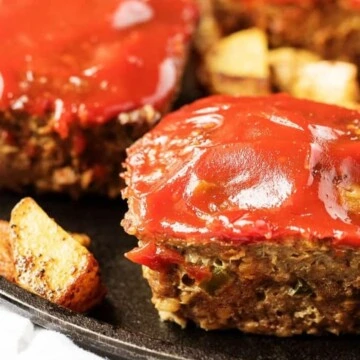 Close up view of mini meatloaves on a cast iron plate.