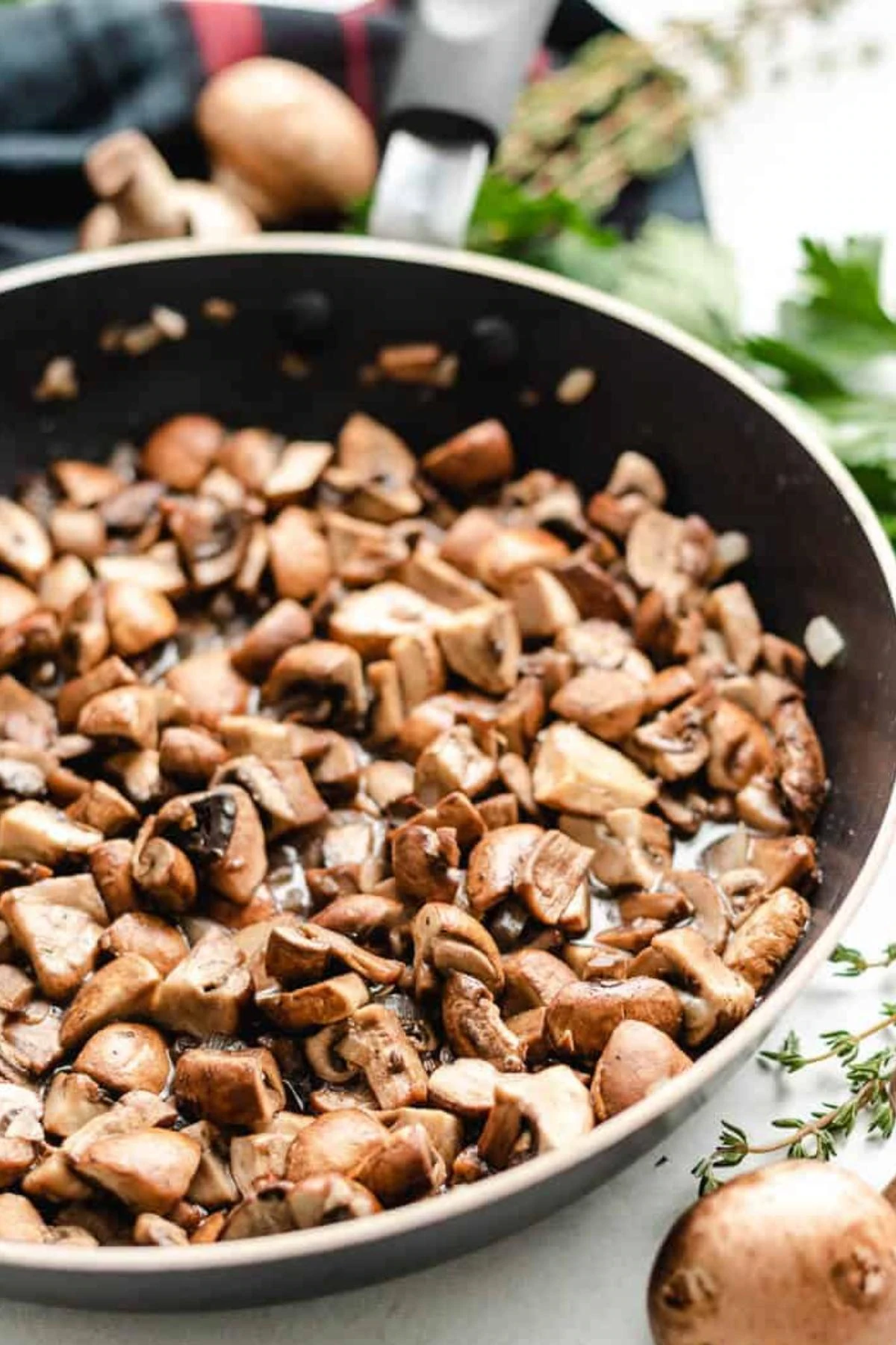 Mushrooms and onions cooking in a skillet.