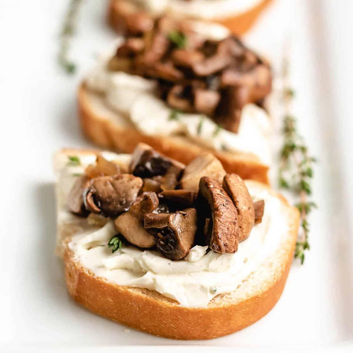 Close up view of a mushroom toast appetizer on a platter.