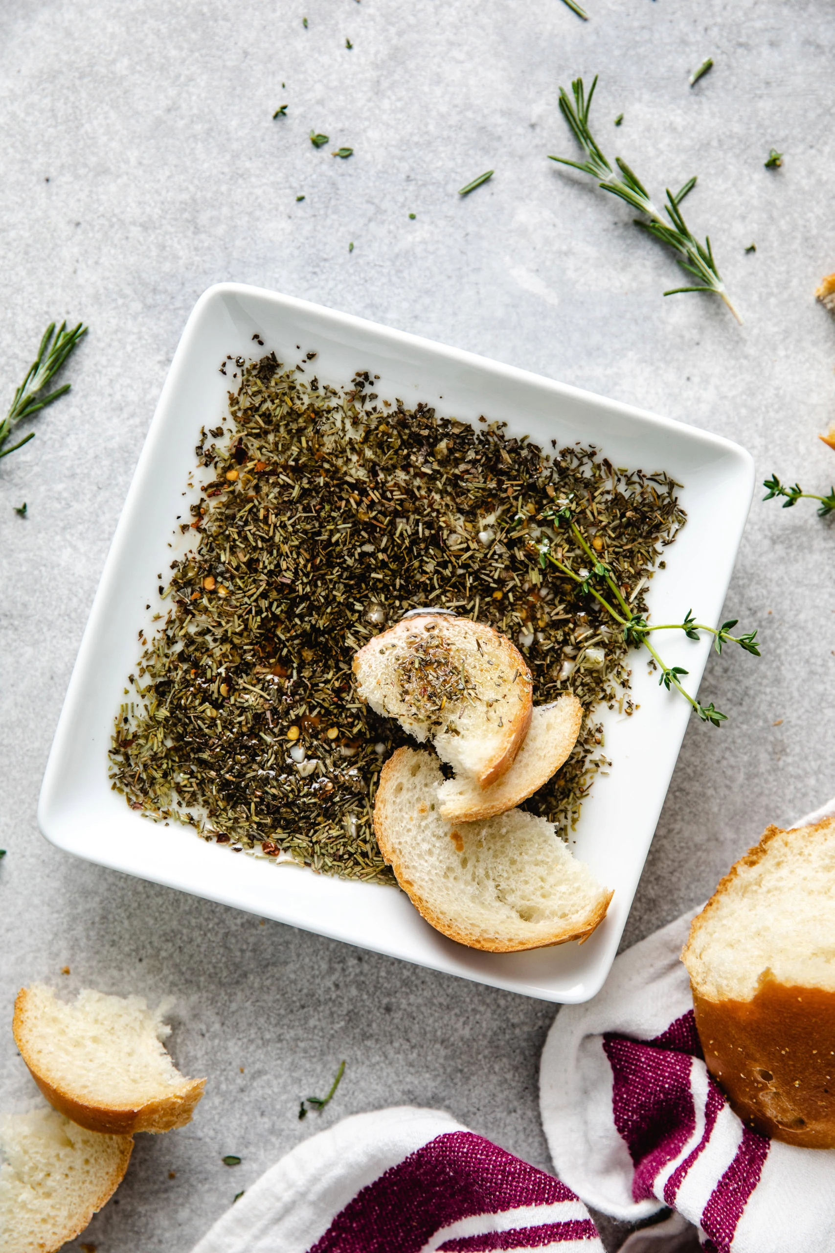 Simple Olive Oil and Balsamic Vinegar Bread Dip with bread and fresh herbs.
