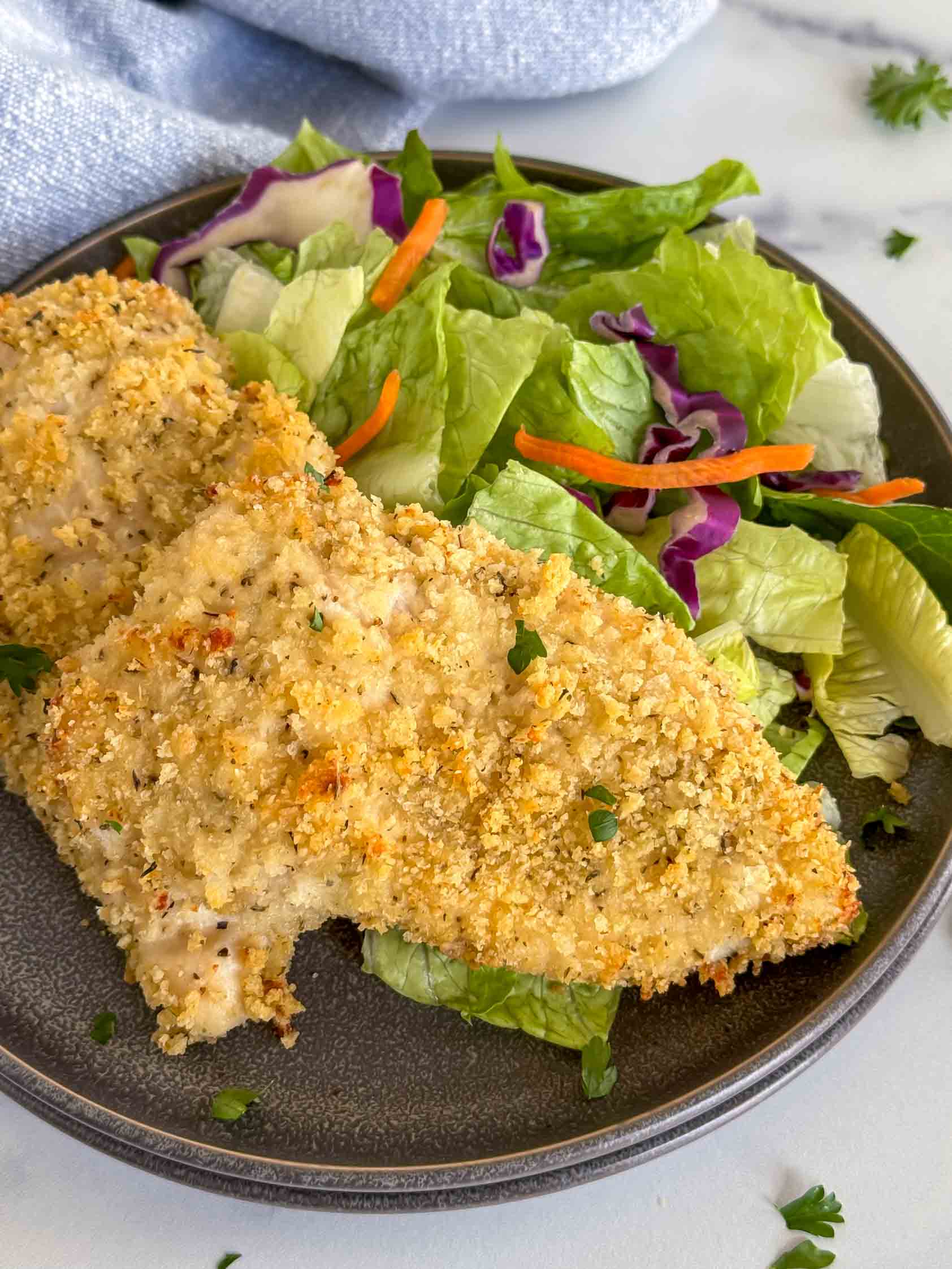 Panko baked chicken breasts on a gray plate.