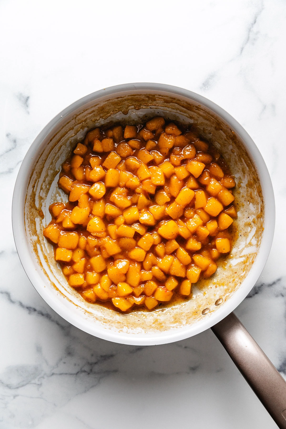 Peach and cinnamon compote in a skillet.