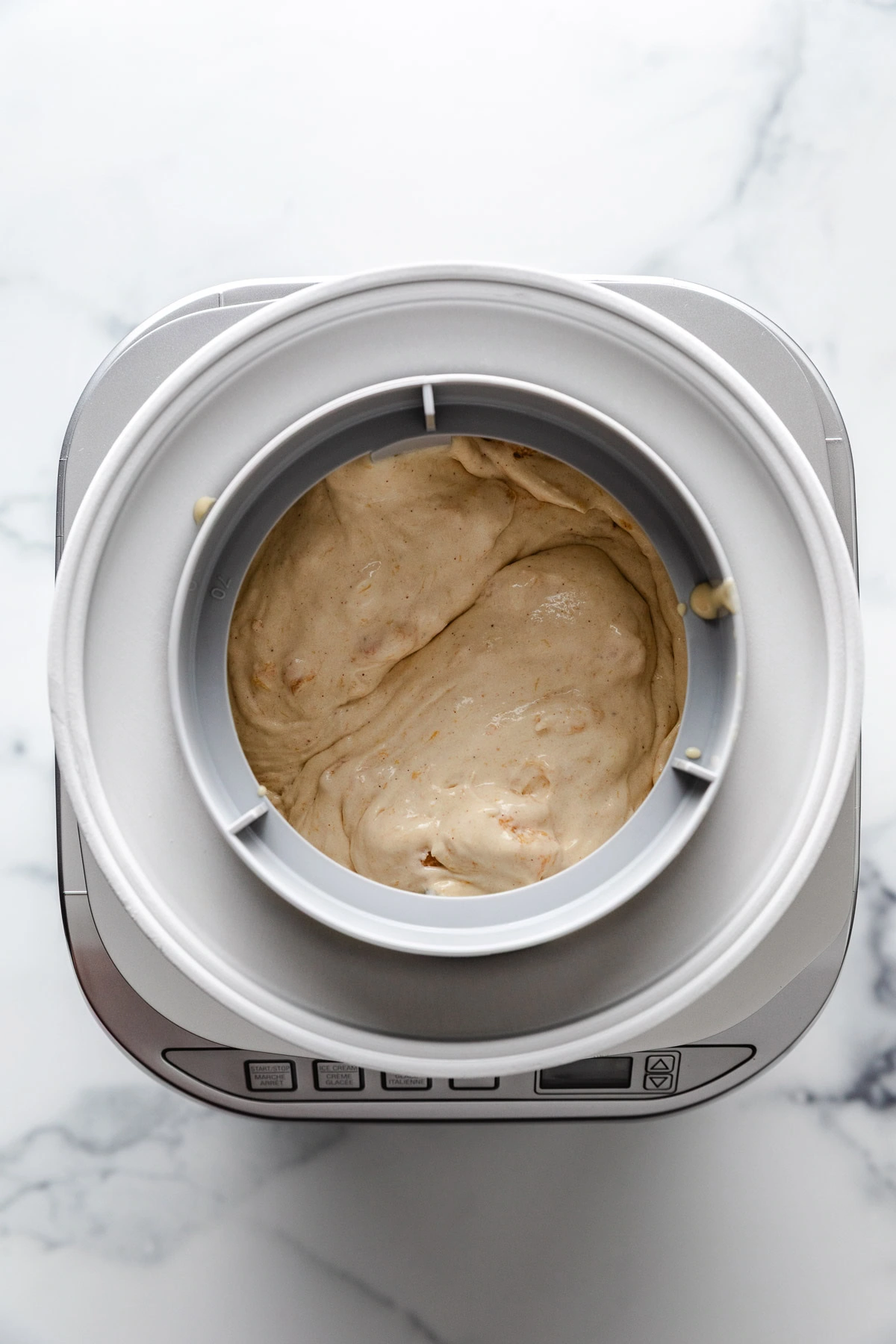 Brown sugar peach ice cream in an ice cream maker.