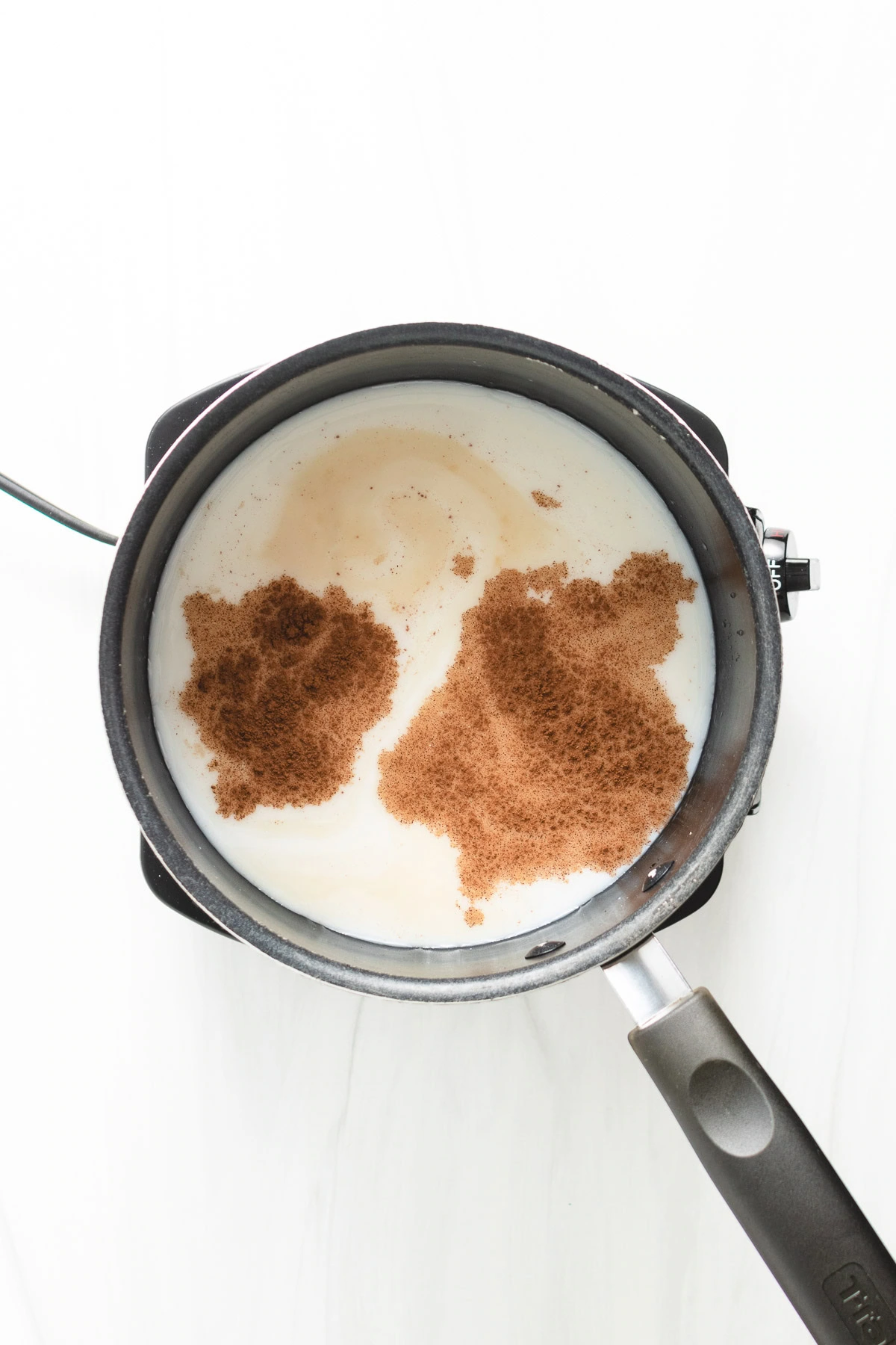 Milk and spices in a pan.