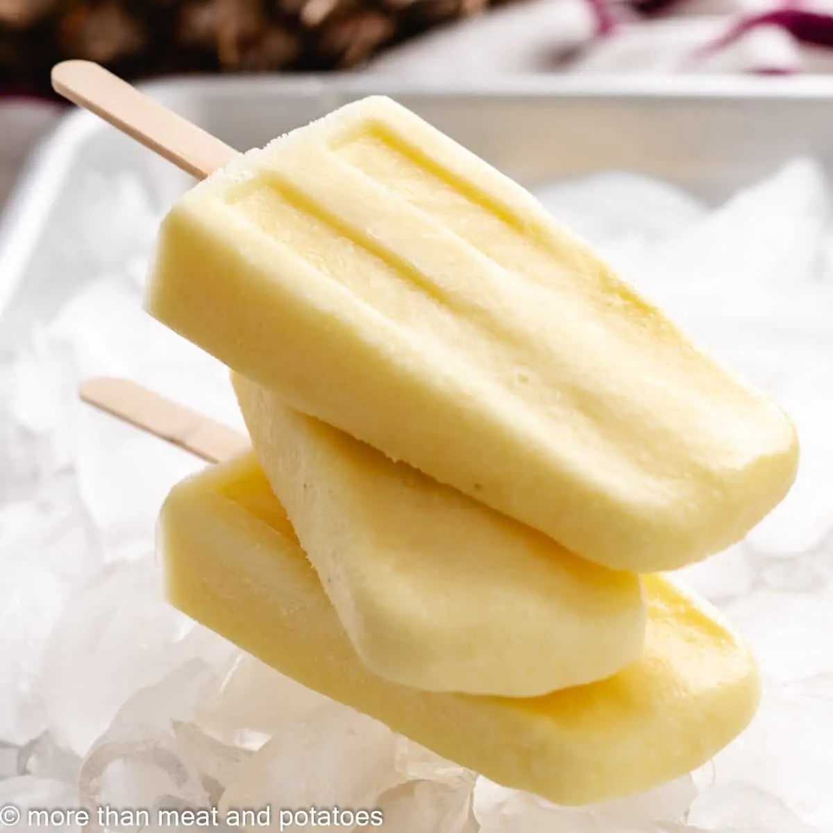 Pineapple popsicles stacked on ice cubes.