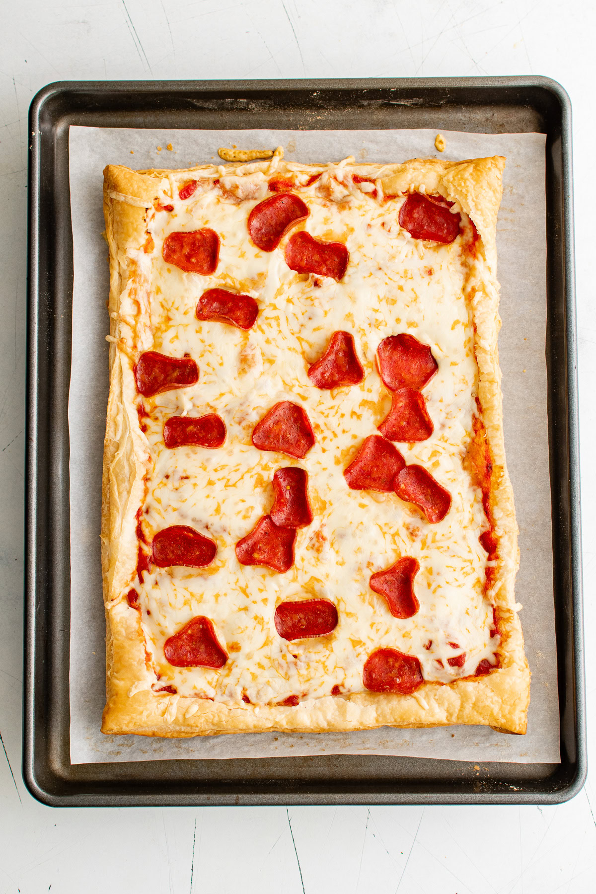 Freshly baked puff pastry pizza on a baking sheet.
