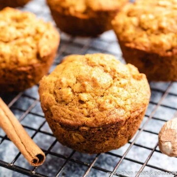 Freshly baked pumpkin oatmeal muffins on a cooling rack.