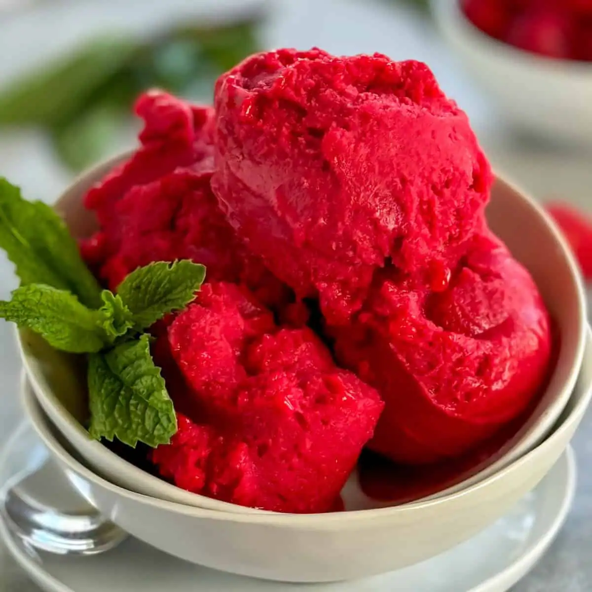 Scoops of raspberry sorbet in a bowl.