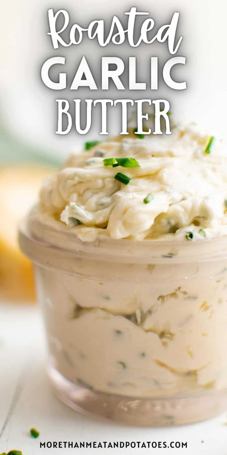 Close up view of a jar of creamy roasted garlic butter.