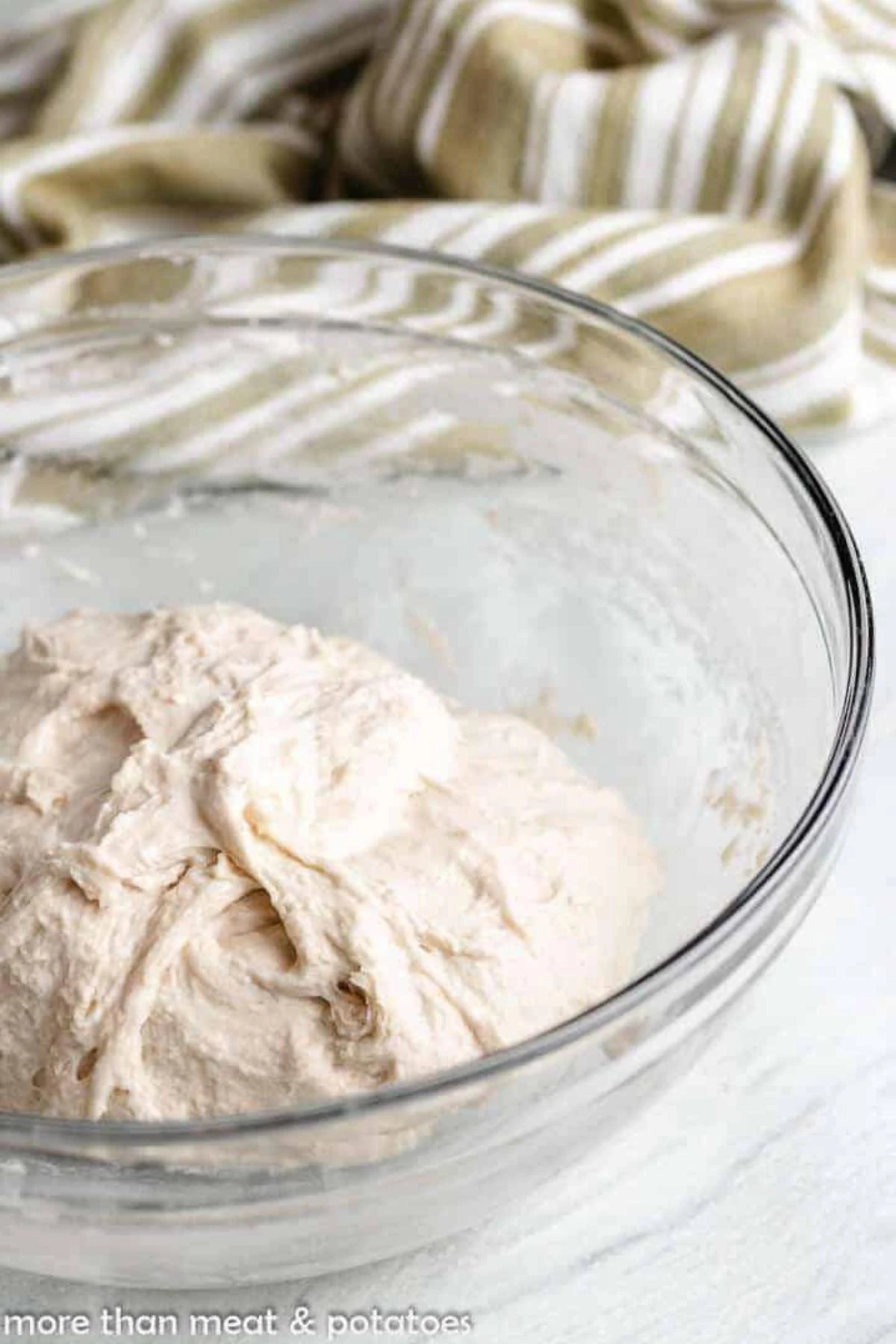 Shaggy sourdough bread dough in a glass bowl.