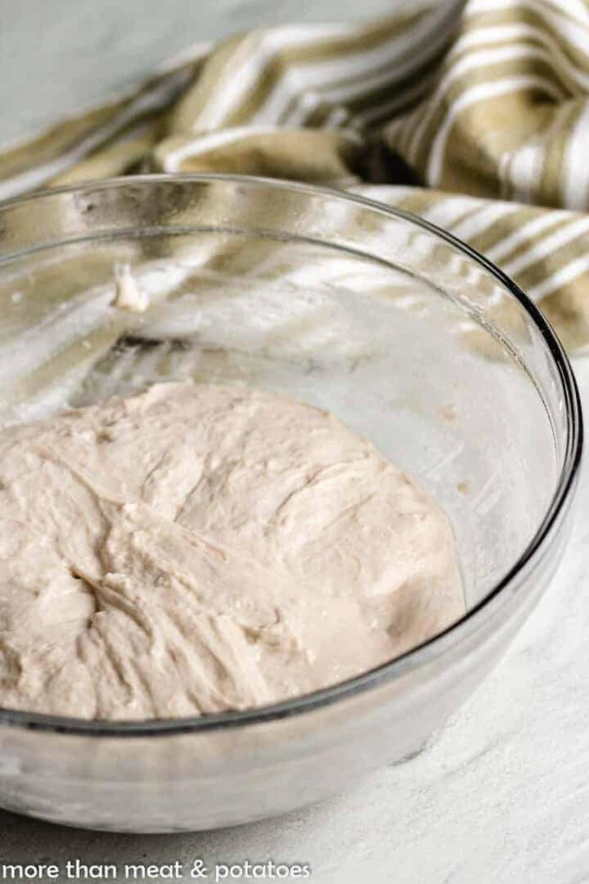Dough resting in a glass bowl.