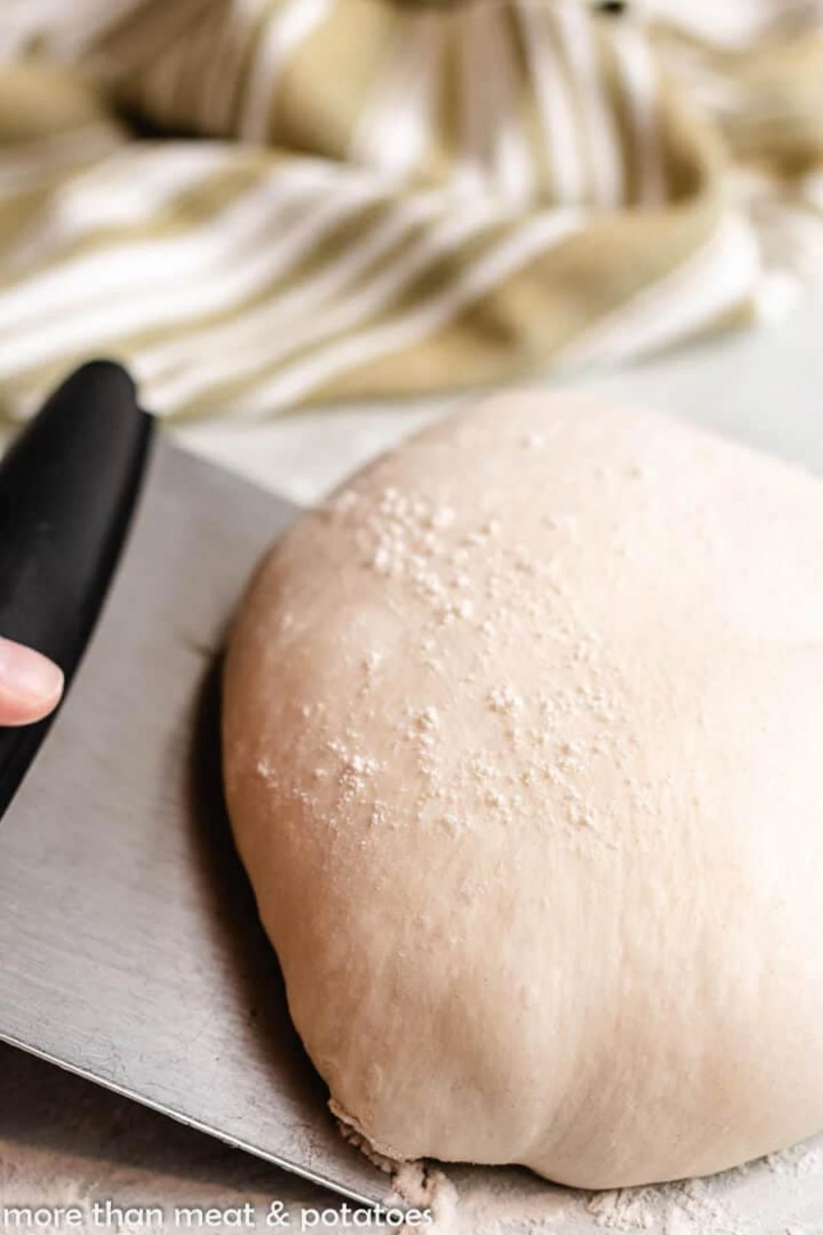 Sourdough bread being shaped on a counter.