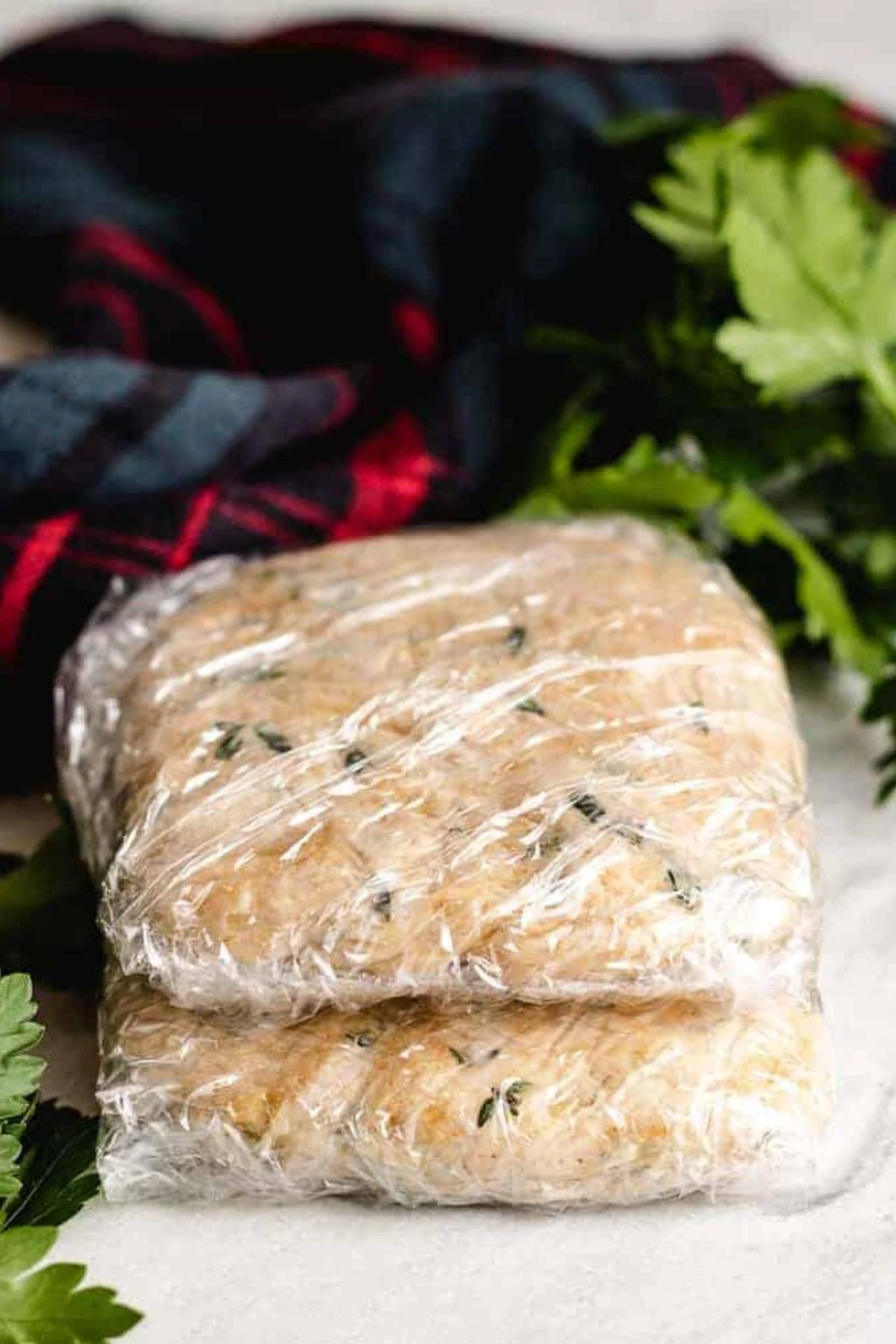 Sourdough cracker dough wrapped in plastic wrap.
