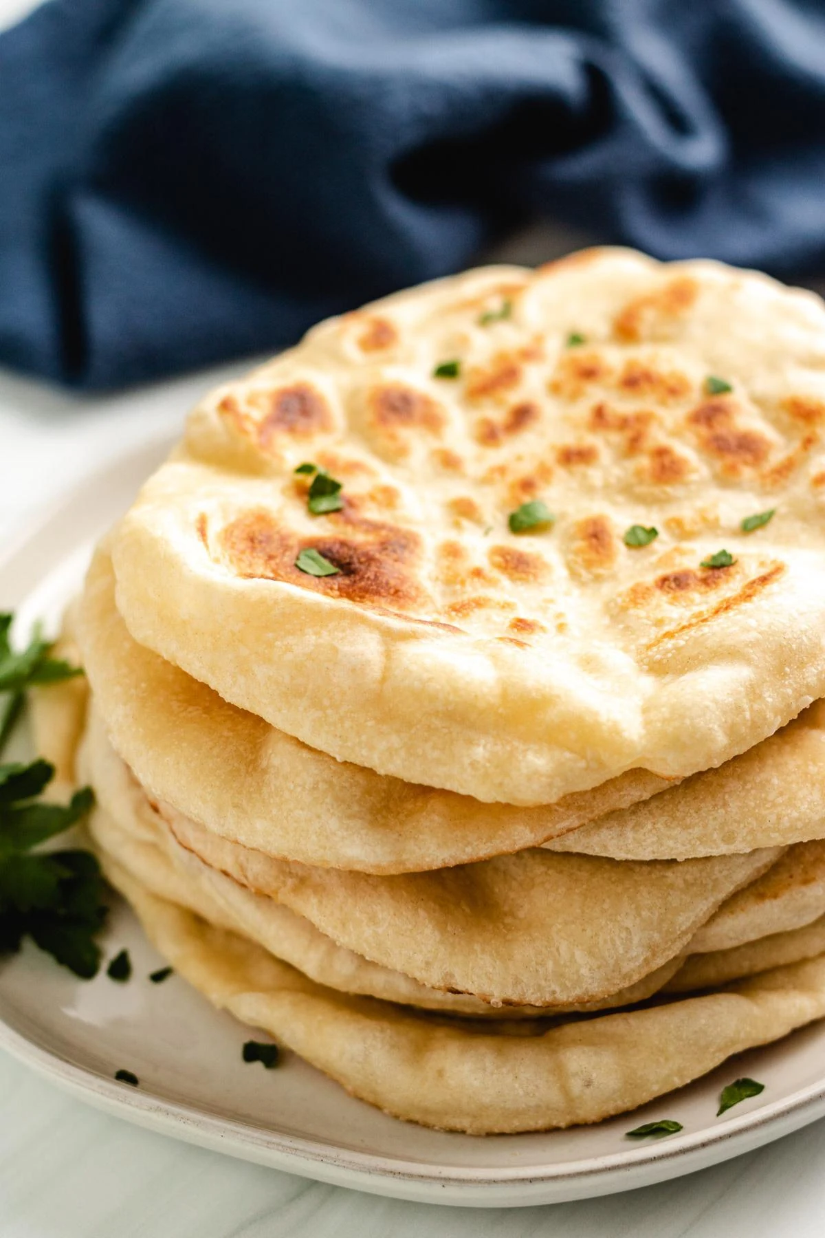 Close up view of sourdough naan bread on a plate.