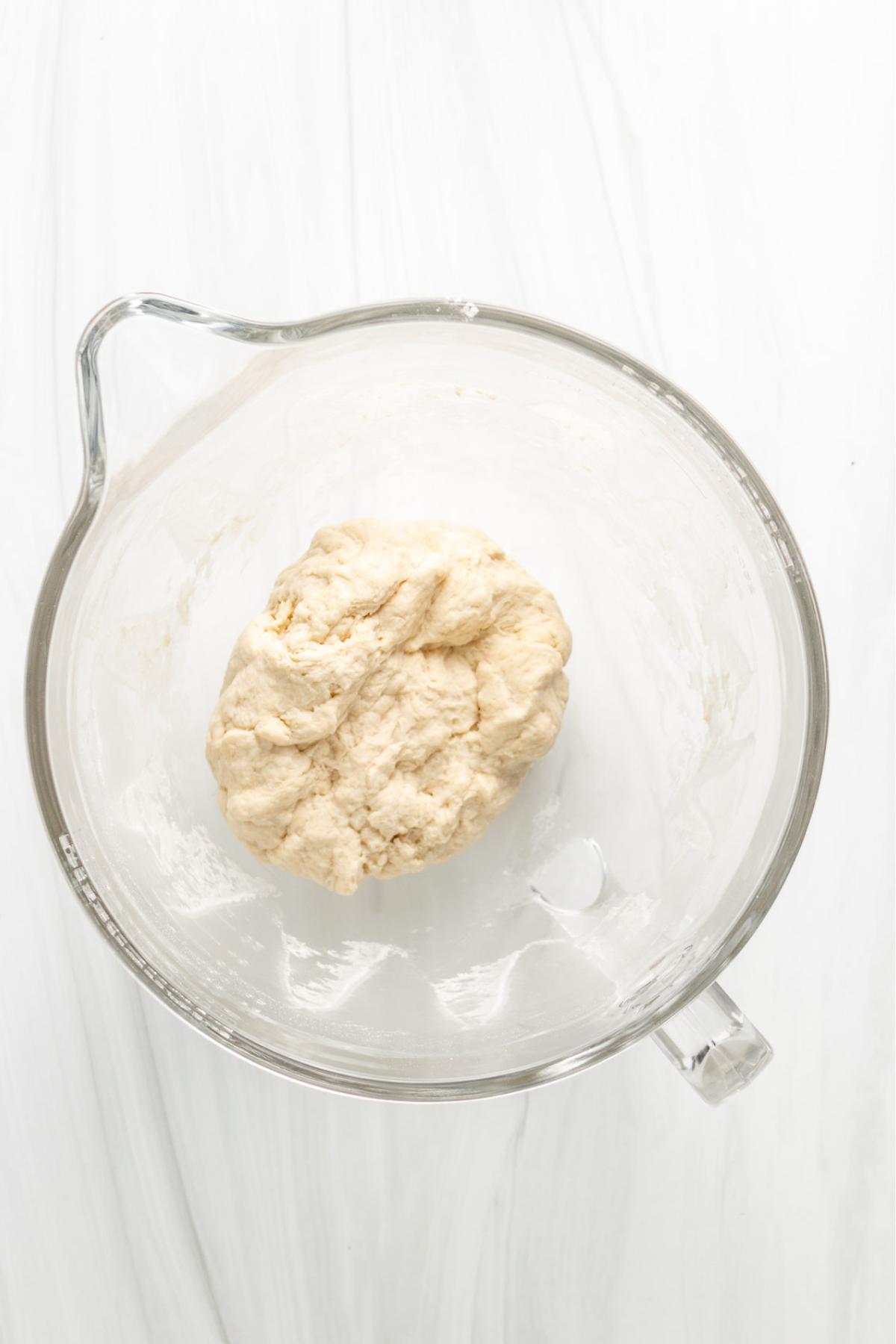 Sourdough naan dough in the bowl of a stand mixer.