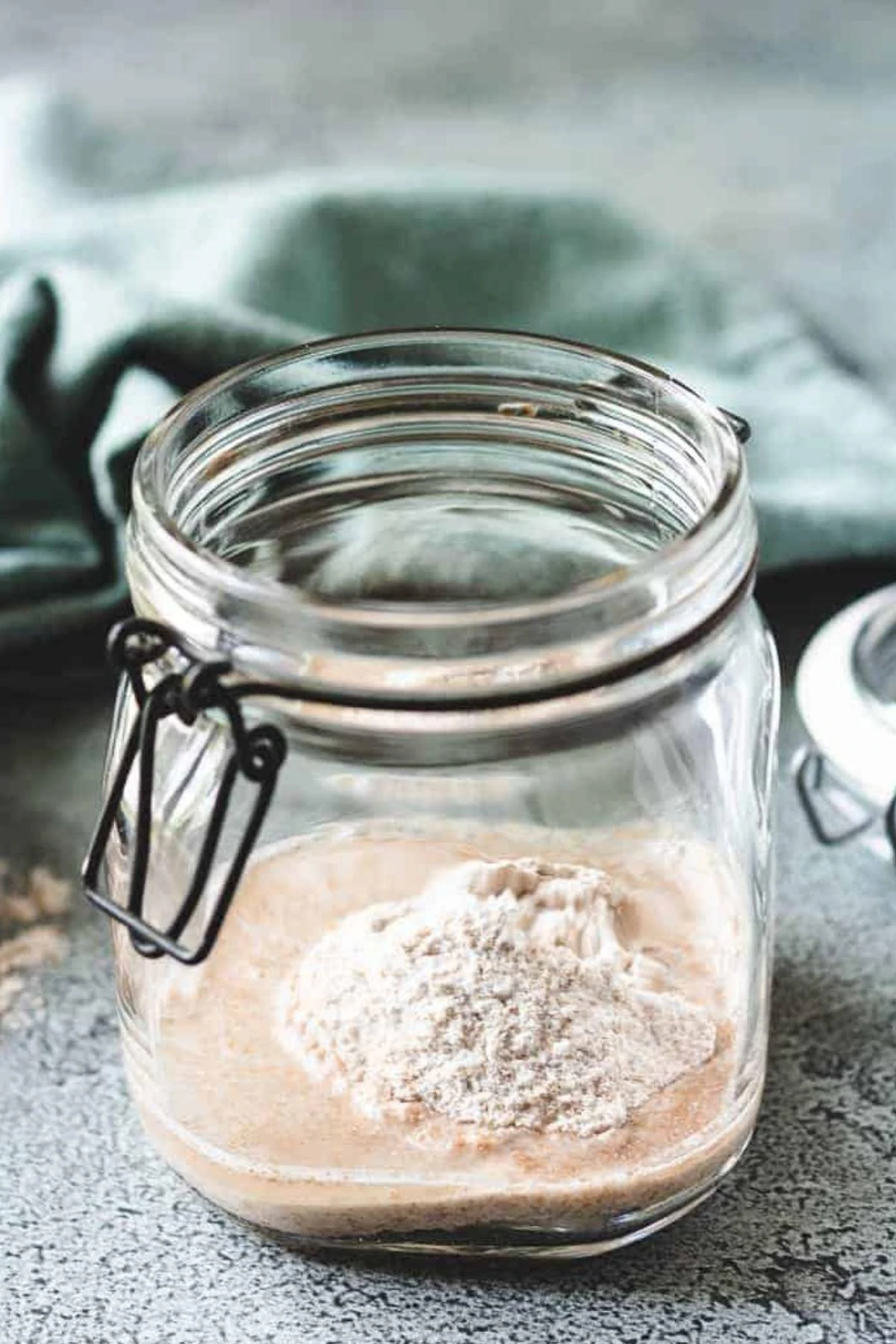 Flour added to a jar while feeding sourdough starter.