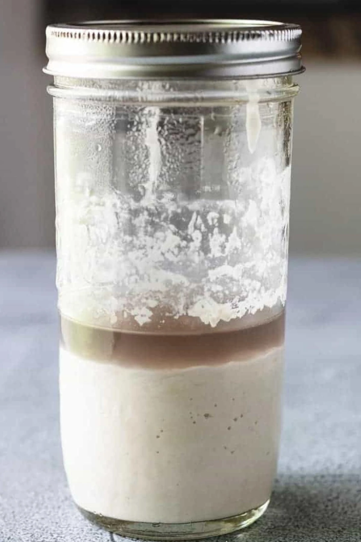 Sourdough starter in a jar with a layer of brown hooch on top.