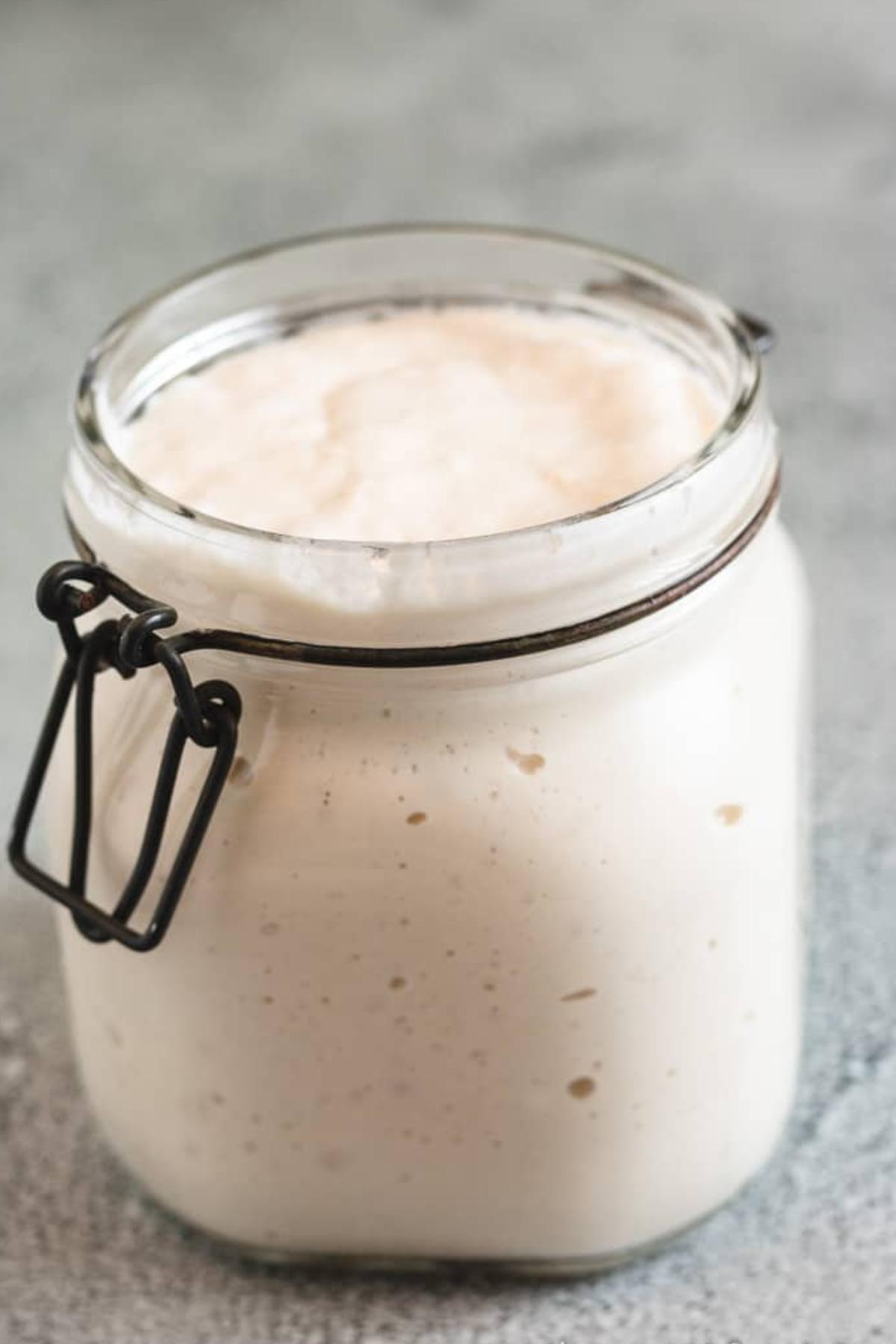 Very active sourdough starter in a glass jar.