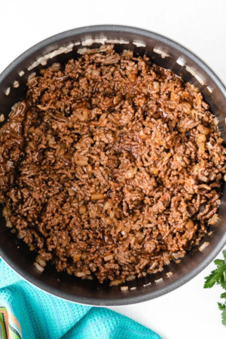 Overhead view of seasoned ground beef in a pot.