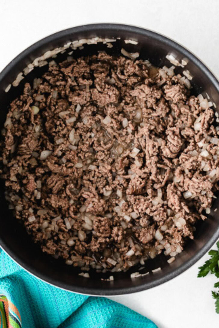 Ground beef and onions cooking in a pot.