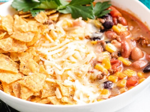 Close up view of taco soup in a white dish.