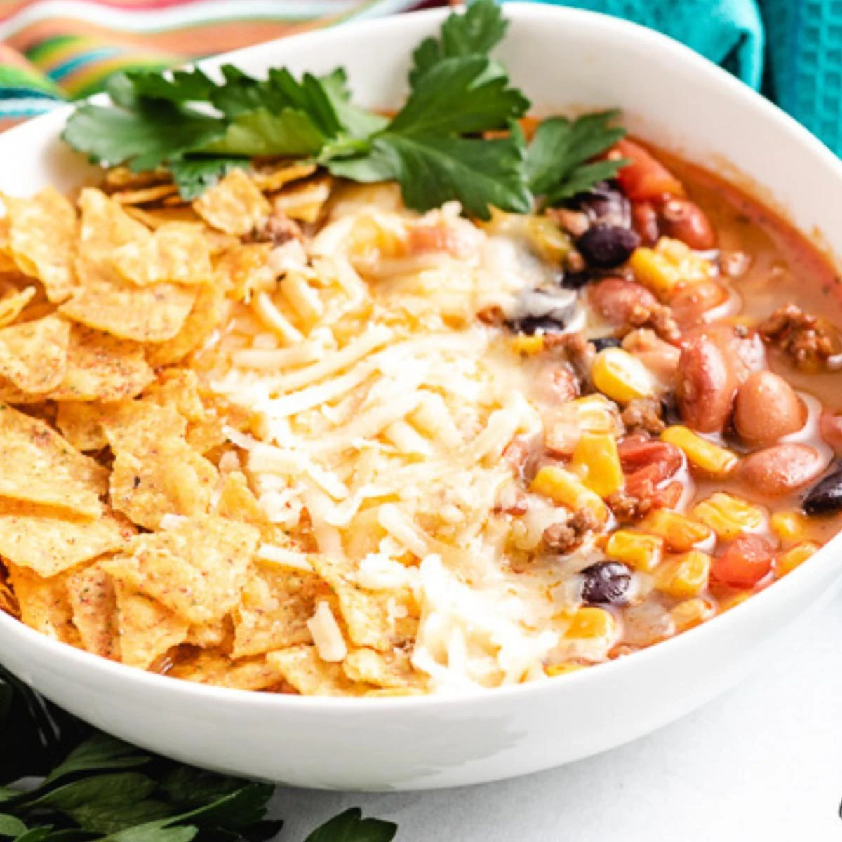 Close up view of taco soup in a white dish.