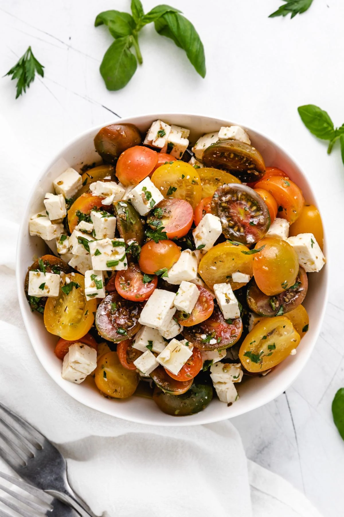 Overhead view of tomato feta salad tossed in white wine vinaigrette.