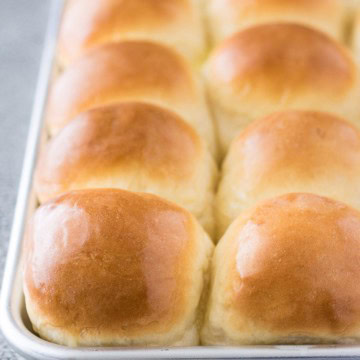 Golden brown yeast rolls on a plate.