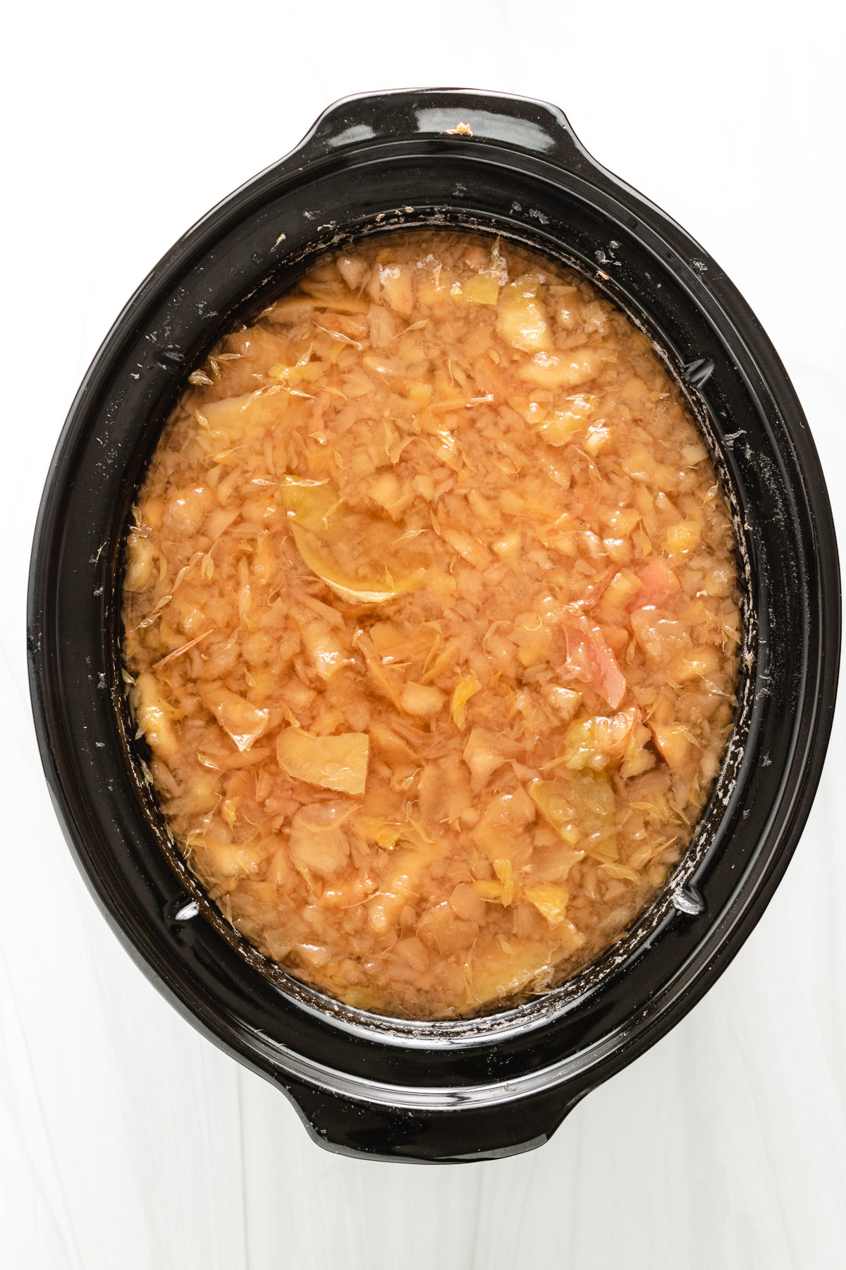 Cooked apples and oranges softened in the slow cooker.