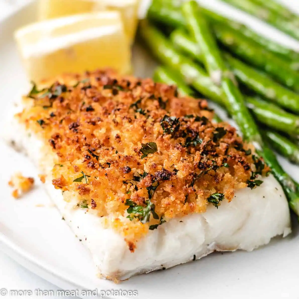 Baked cod with panko on a light colored plate.