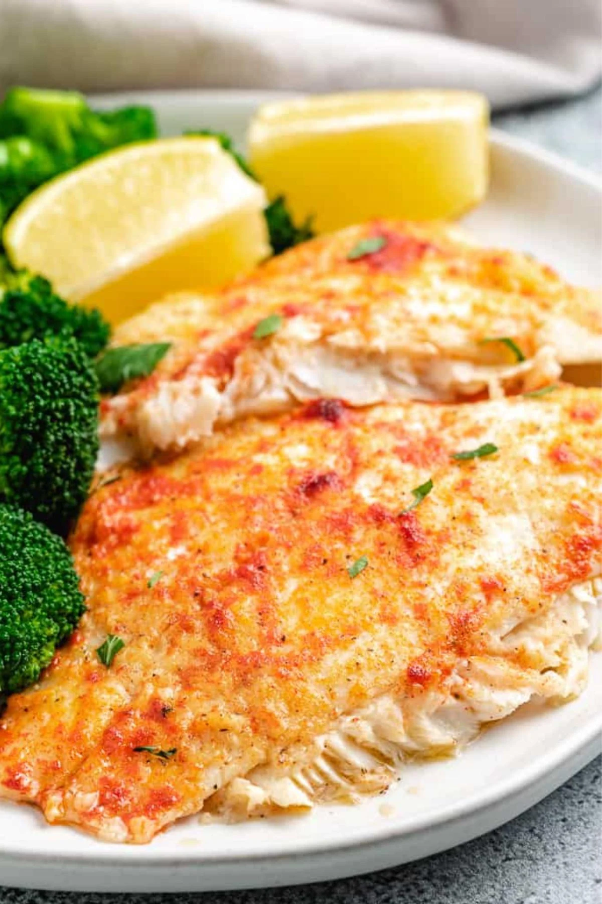 Seasoned flounder fillets on a light colored plate.