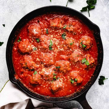 Overhead view of baked meatballs in marinara.