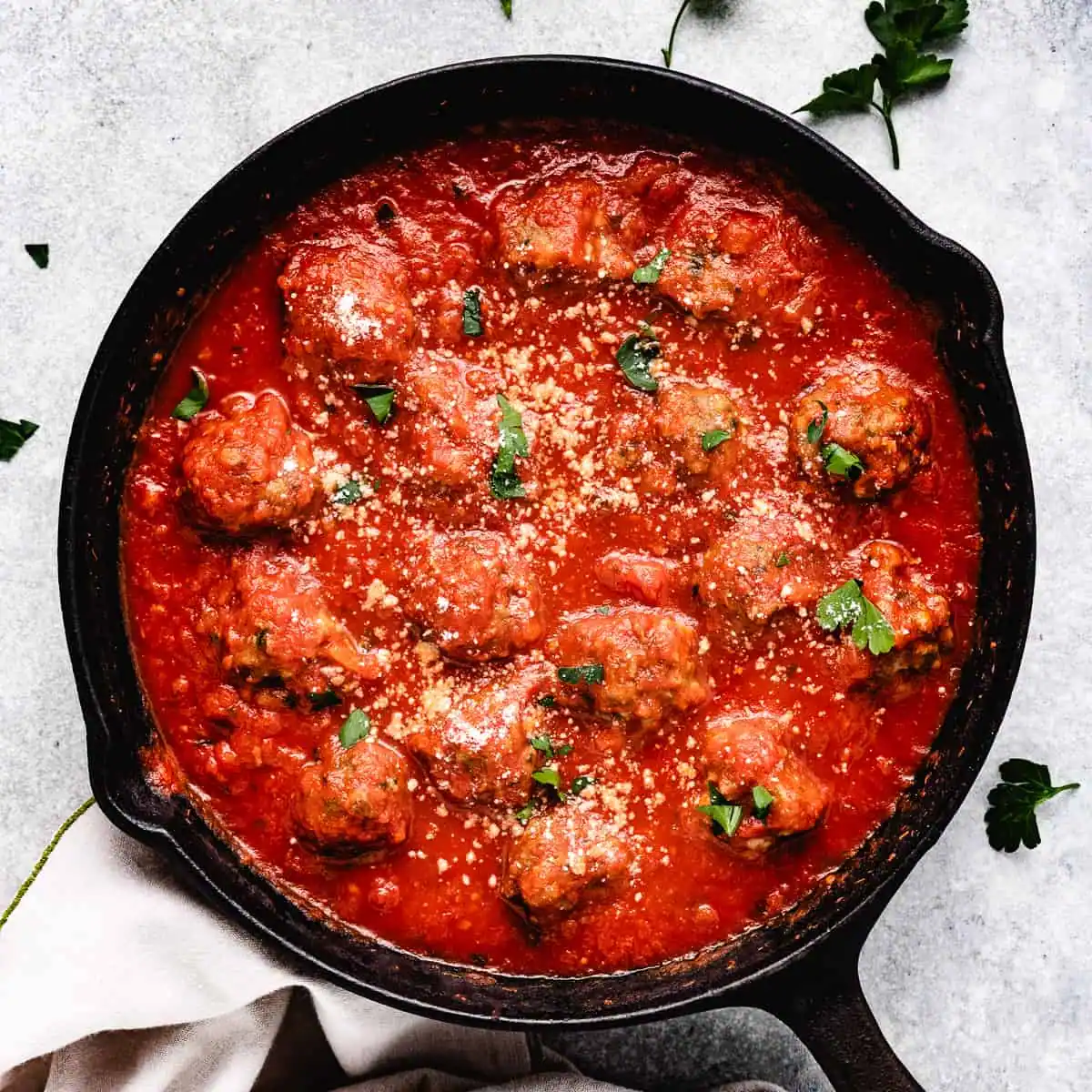 Overhead view of baked meatballs in marinara.