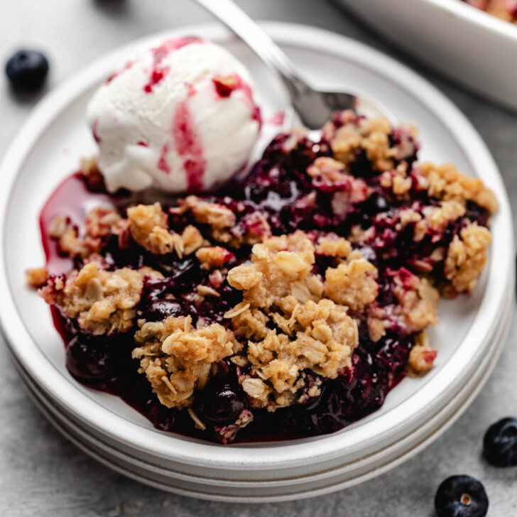 Warm blueberry crisp served with a scoop of vanilla ice cream.