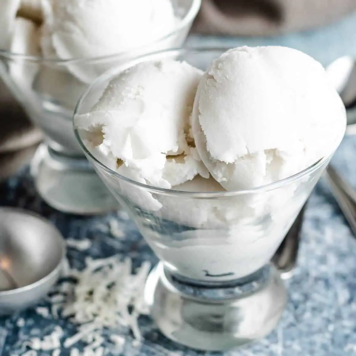 Homemade coconut sorbet scooped into a glass.