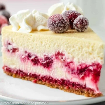 Slice of cranberry cheesecake topped with sugared cranberries.