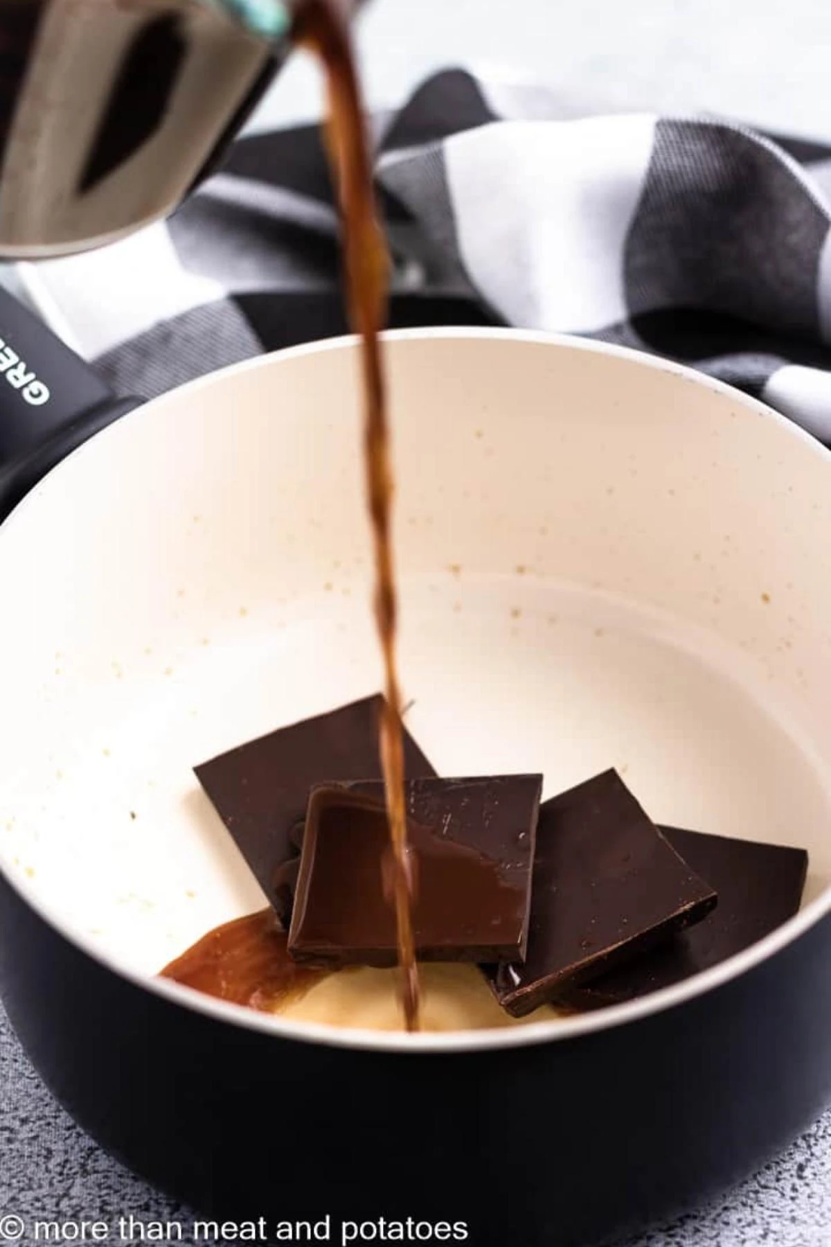 Coffee being poured into a pan with dark chocolate.