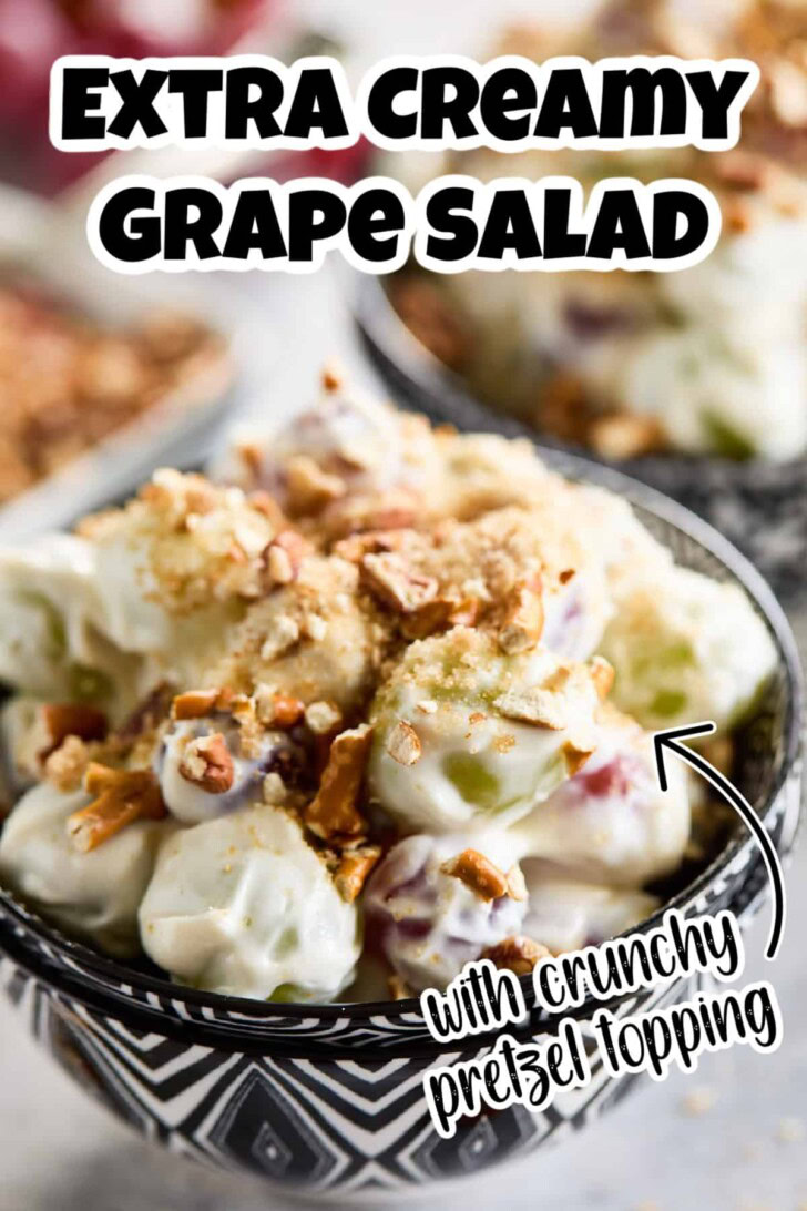 Close up view of grape salad filling a black and white bowl.