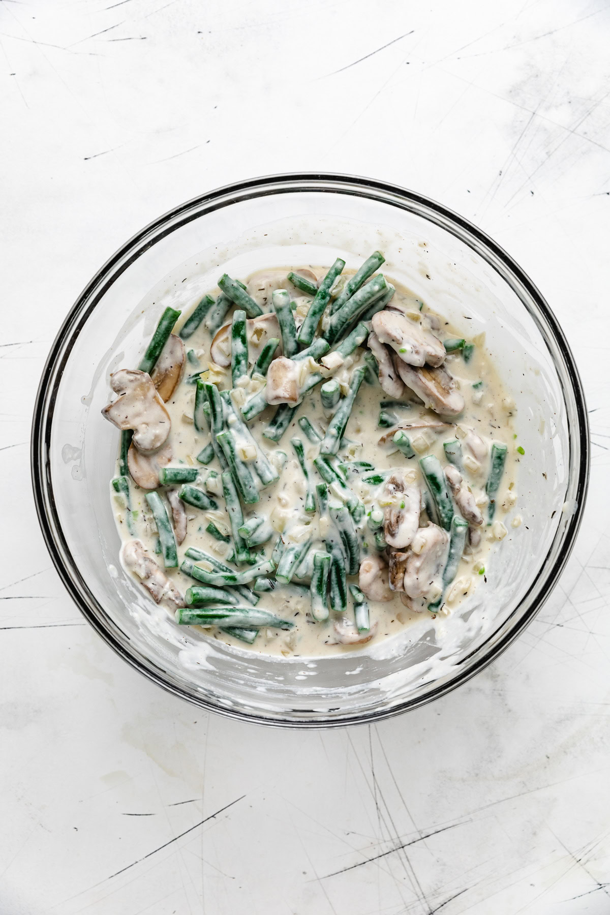 Green bean casserole mixture in a glass bowl.