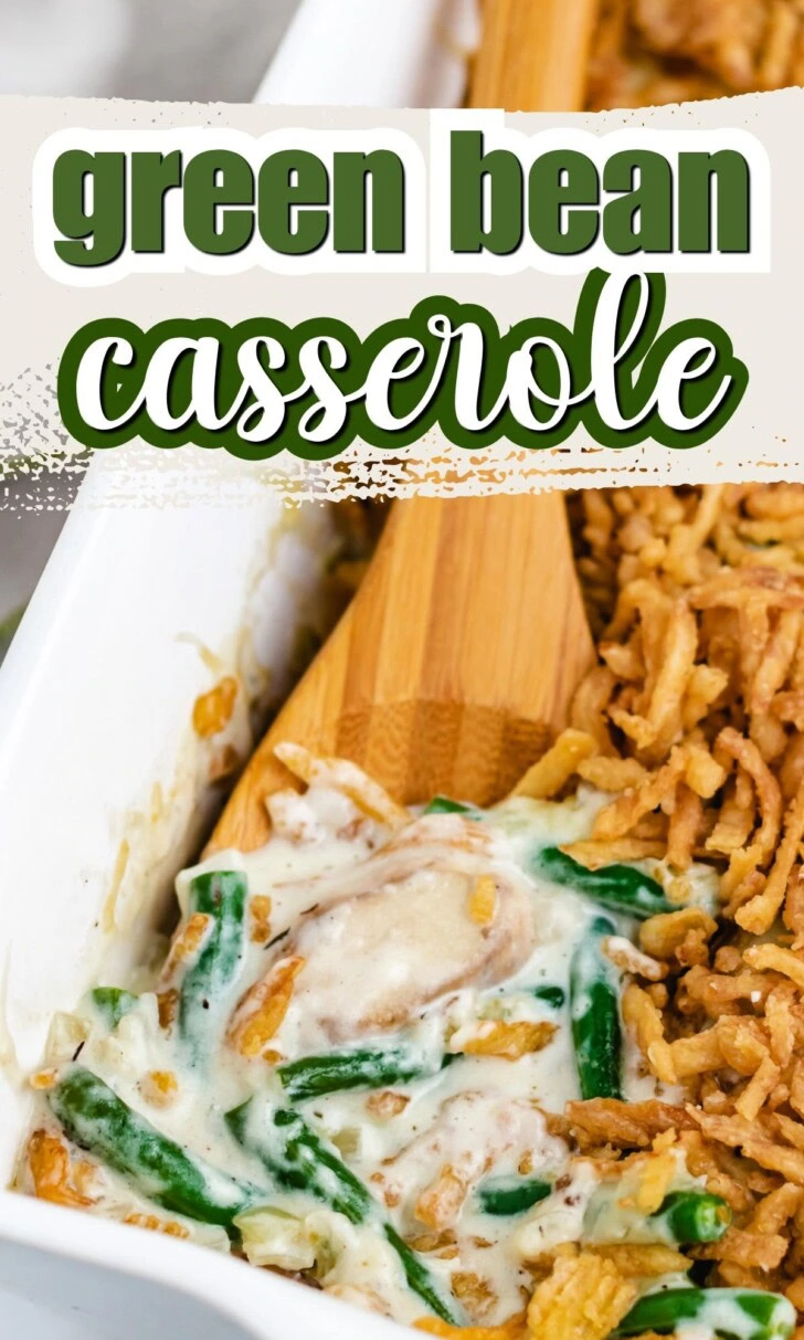 Green bean casserole with mushrooms, crispy fried onions, and a wooden serving spoon.