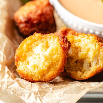 Close up view of a plate of hush puppies.