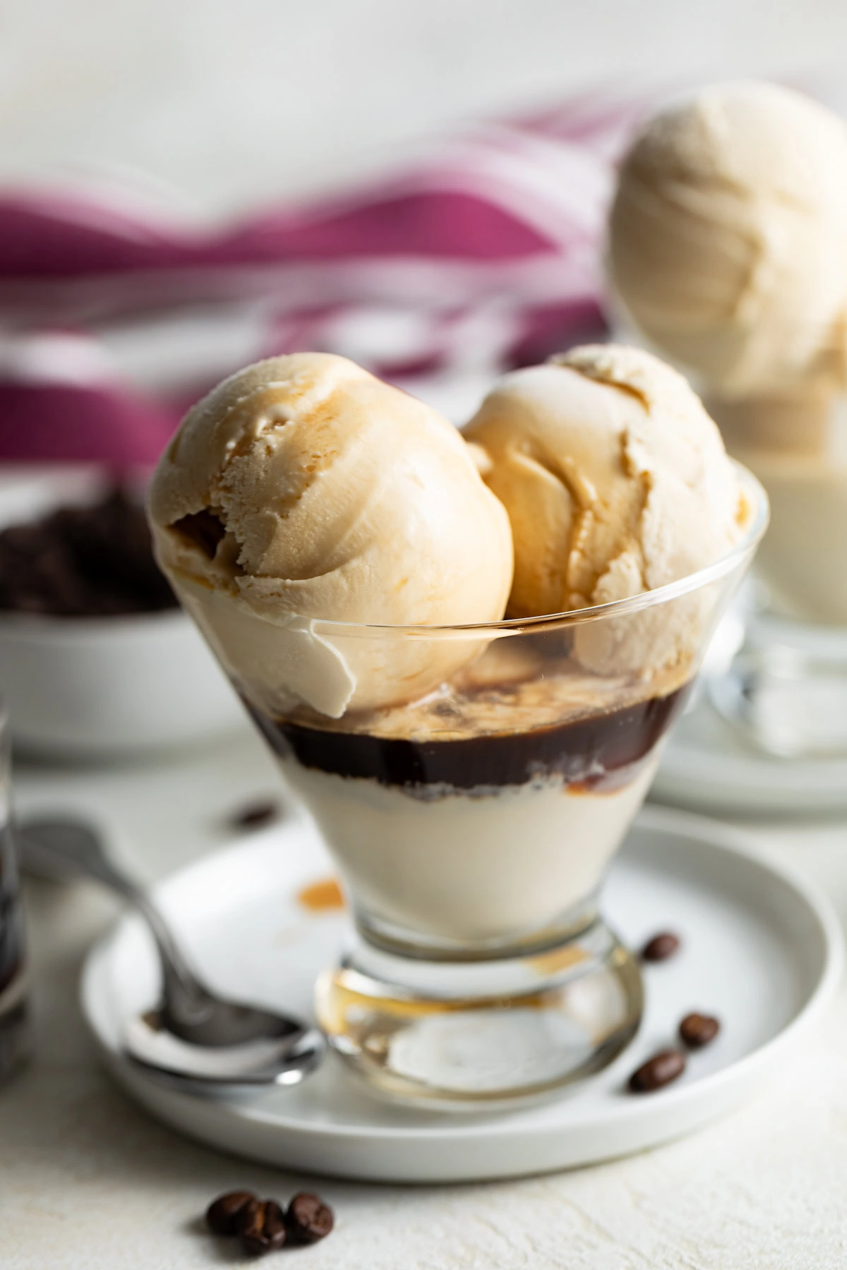 Scoops of Kahlua ice cream topped with Kahlua in a glass.