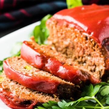 Close up view of sliced meatloaf on a platter.